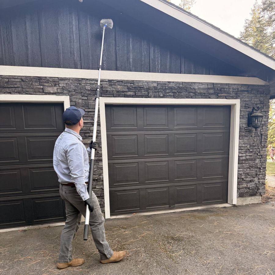 Clearing webs from the eaves above a garage